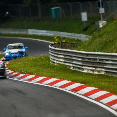 Drei Rennautos fahren hintereinander auf dem Nürburgring.