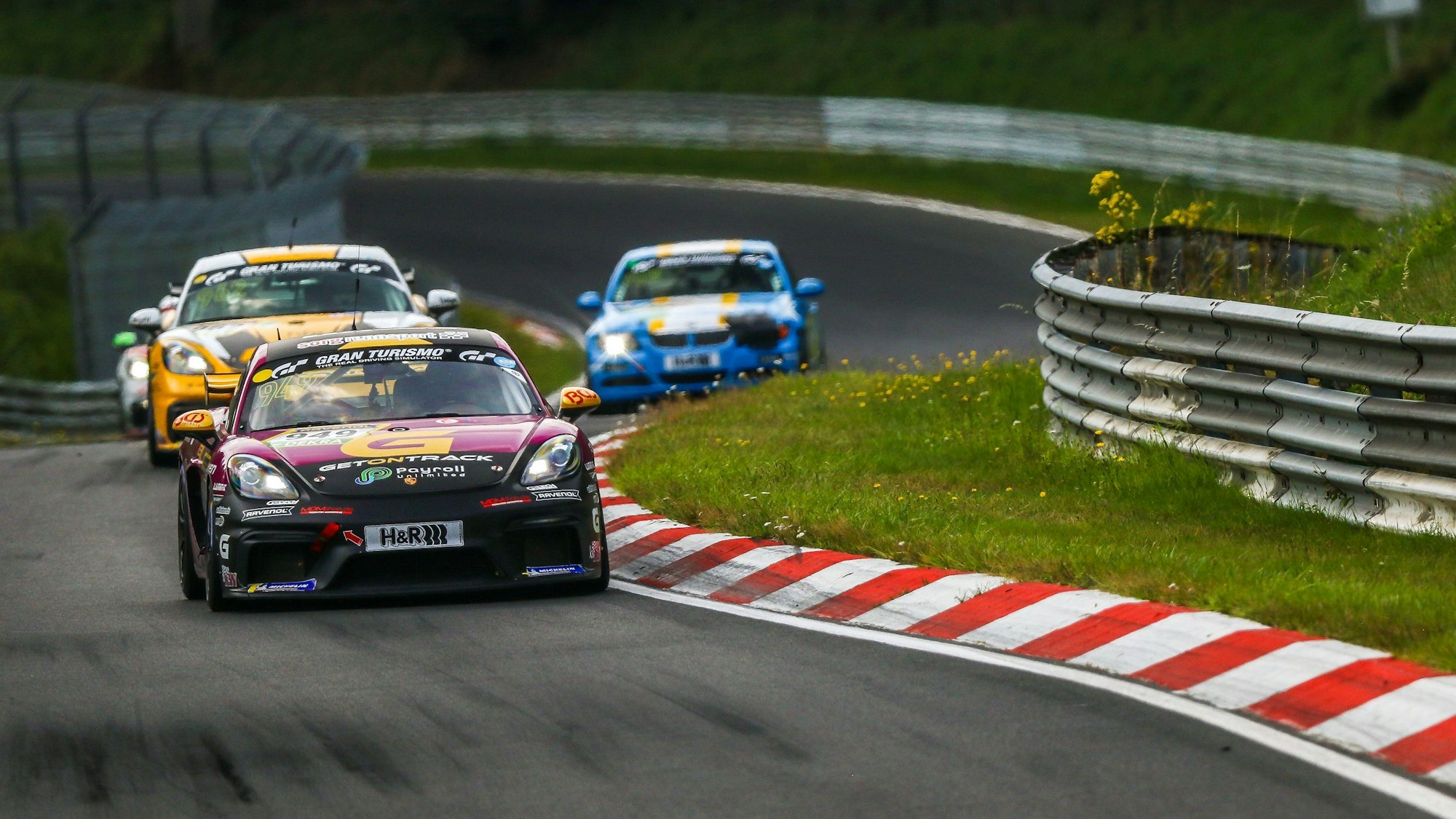 Drei Rennautos fahren hintereinander auf dem Nürburgring.