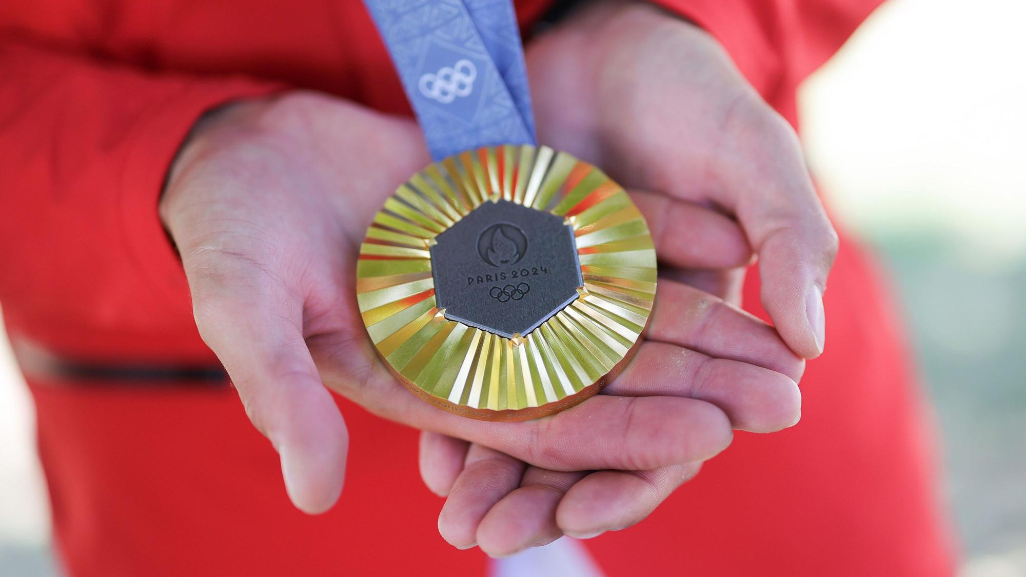 06.08.2024, Frankreich, Paris: Olympia, Paris 2024, Pferdesport, Springen, Einzel, Finale, Deutschlands Christian Kukuk zeigt nach der Siegerehrung seine Goldmedaille. Foto: Rolf Vennenbernd/dpa +++ dpa-Bildfunk +++