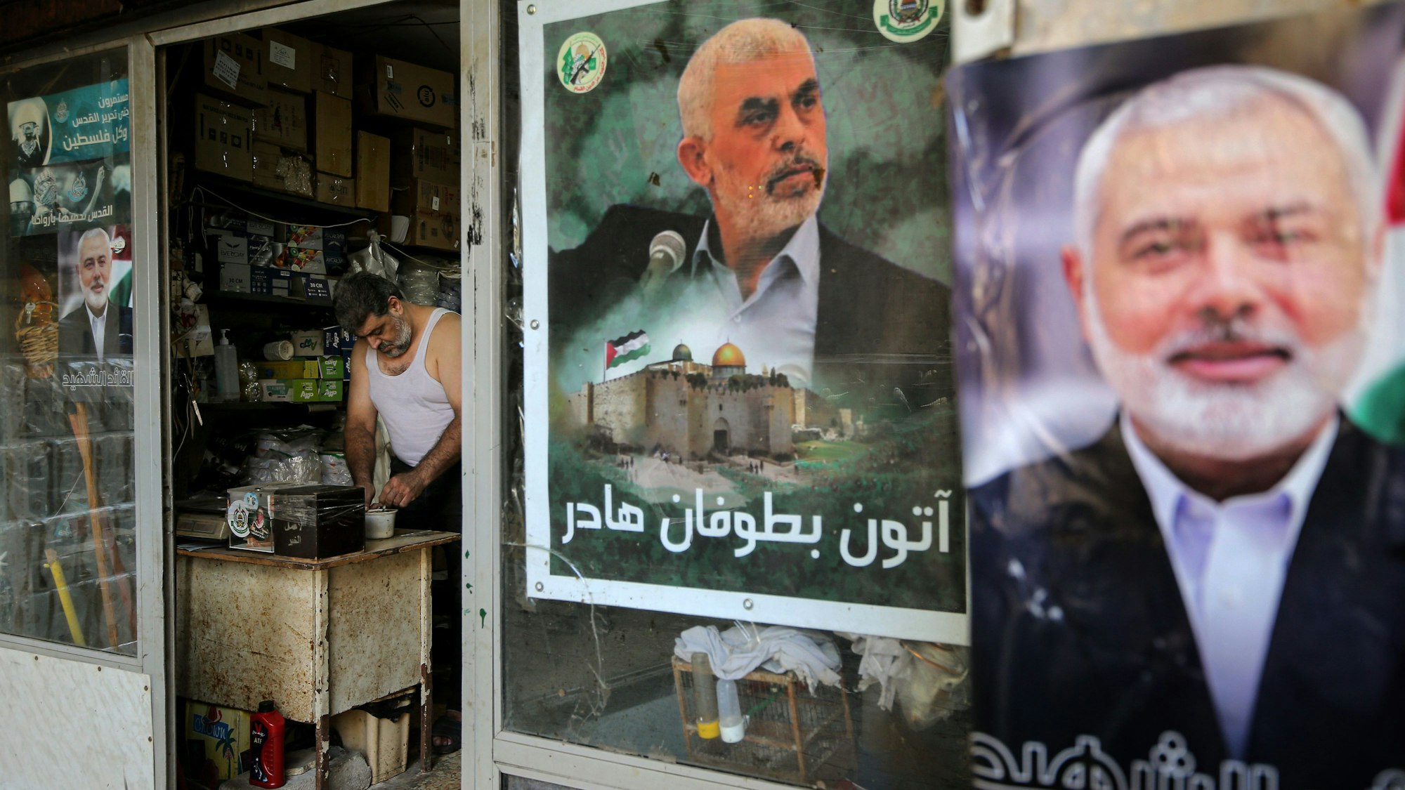 07.08.2024, Libanon, Beirut: Ein palästinensischer Flüchtling arbeitet in seinem Laden im Lager Burj el-Barjneh, der mit Plakaten des ehemaligen Hamas-Führers Hanija (r) und von Sinwar (M), der zum Nachfolger von Hanija ernannt wurde, geschmückt ist. Knapp eine Woche nach der Tötung von Hamas-Auslandschef Ismail Hanija hat die islamistische Terrorgruppe Sinwar zum neuen Anführer der Organisation bestimmt. Das teilte die Hamas auf der Plattform Telegram mit. Foto: Marwan Naamani/dpa +++ dpa-Bildfunk +++