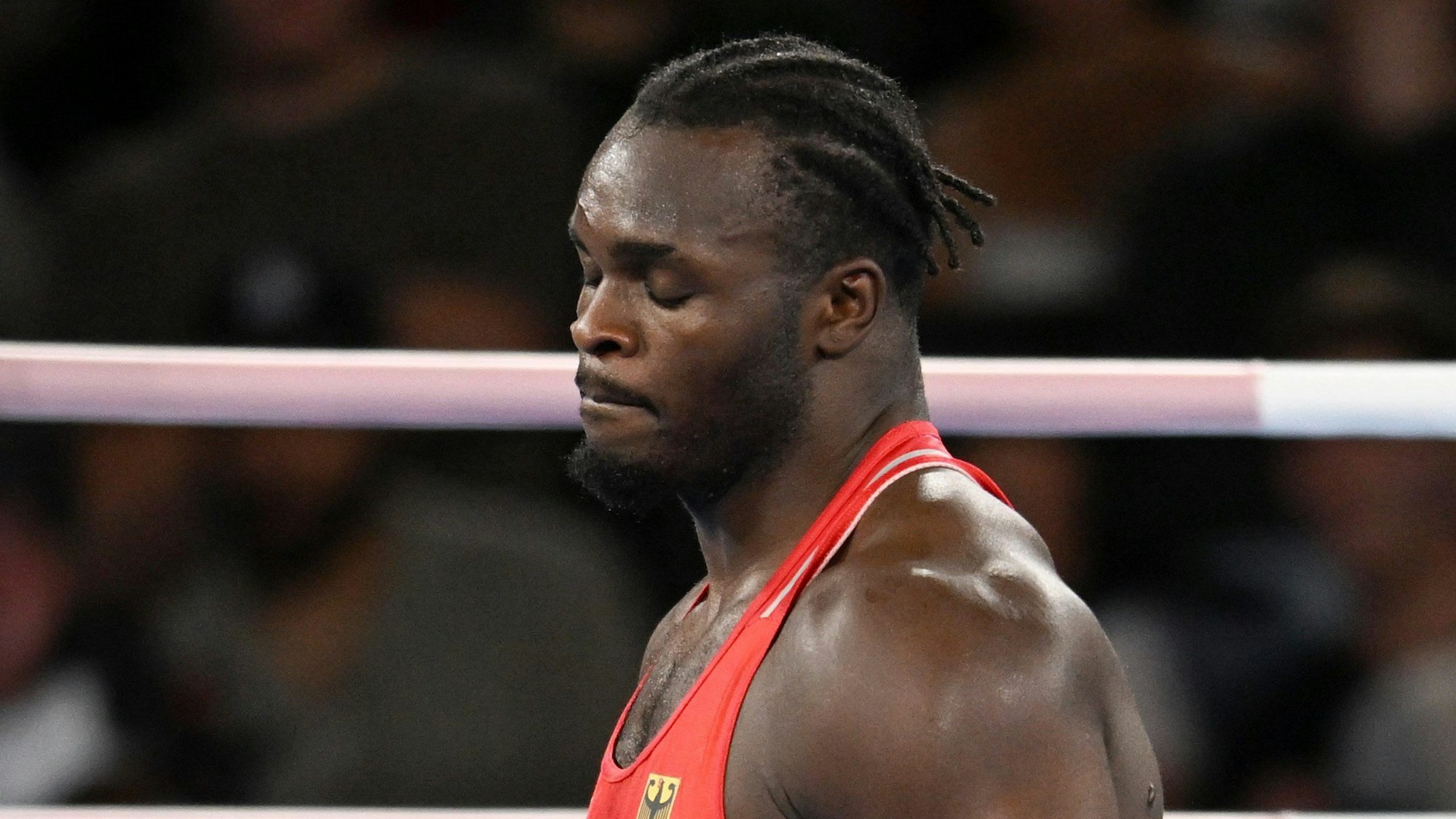 Das Bild zeigt den Boxer Nelvie Tiafack mit geschlossenen Augen nach dem verlorenen Boxkampf.