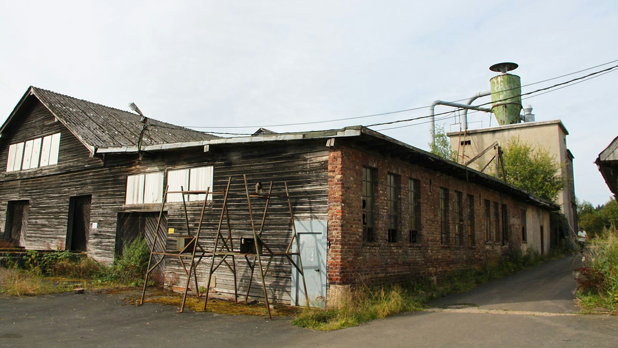 Das alte Sägewerk hat auf einer Seite eine Holzfassade, auf der anderen eine Backsteinmauer.