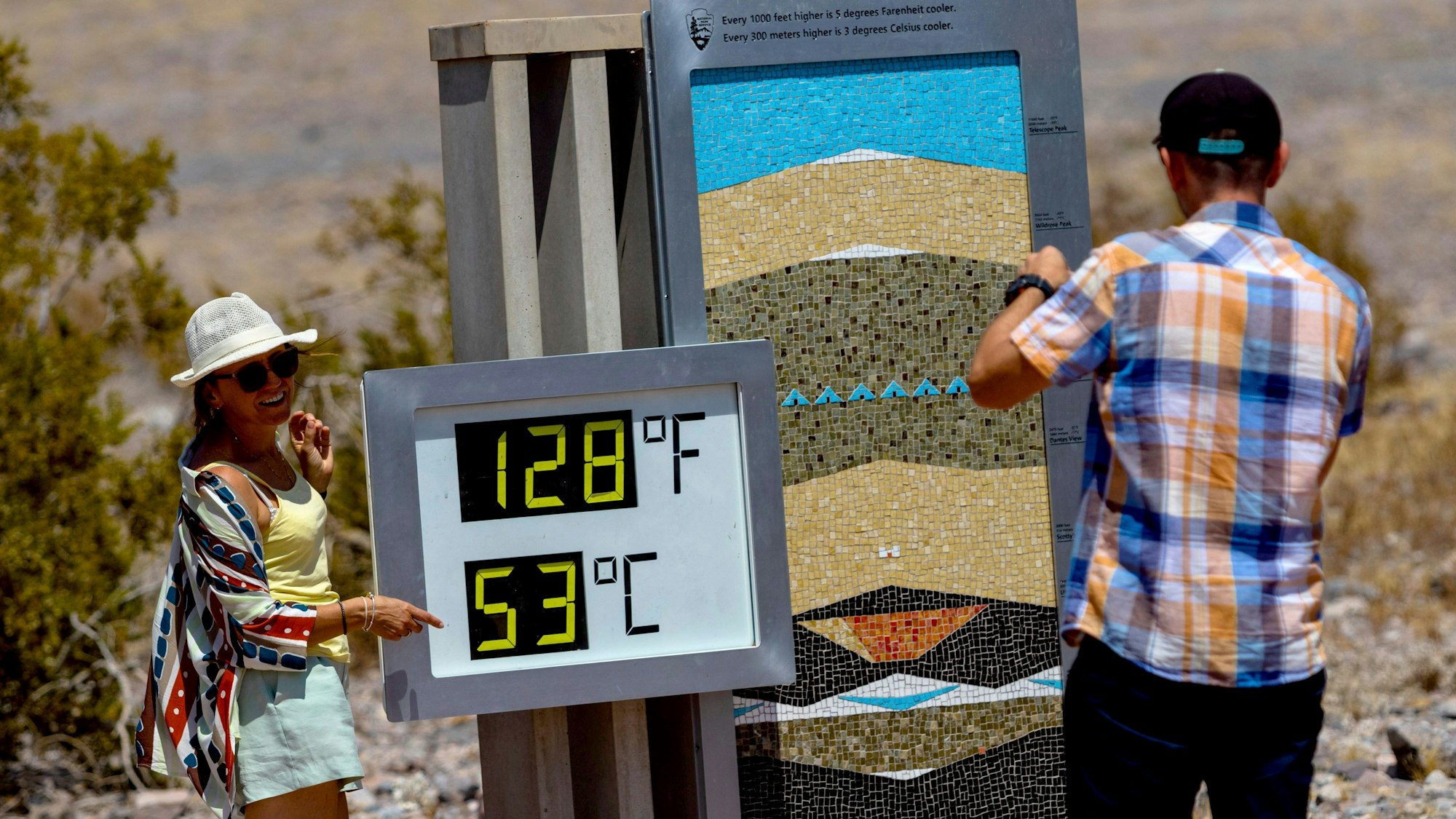 Touristen fotografieren ein Thermometer im Furnace Creek Visitor Center während einer Hitzewelle im Death Valley. (Archivbild)
