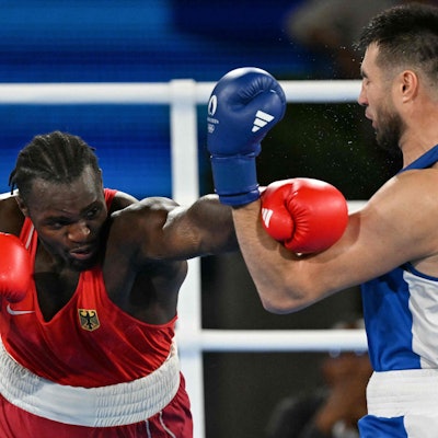 Germany's Nelvie Raman Tiafack and Uzbekistan's Bakhodir Jalolov (Blue) compete in the men's +92kg semi-final boxing match during the Paris 2024 Olympic Games at the Roland-Garros Stadium, in Paris on August 7, 2024. (Photo by MOHD RASFAN / AFP)
