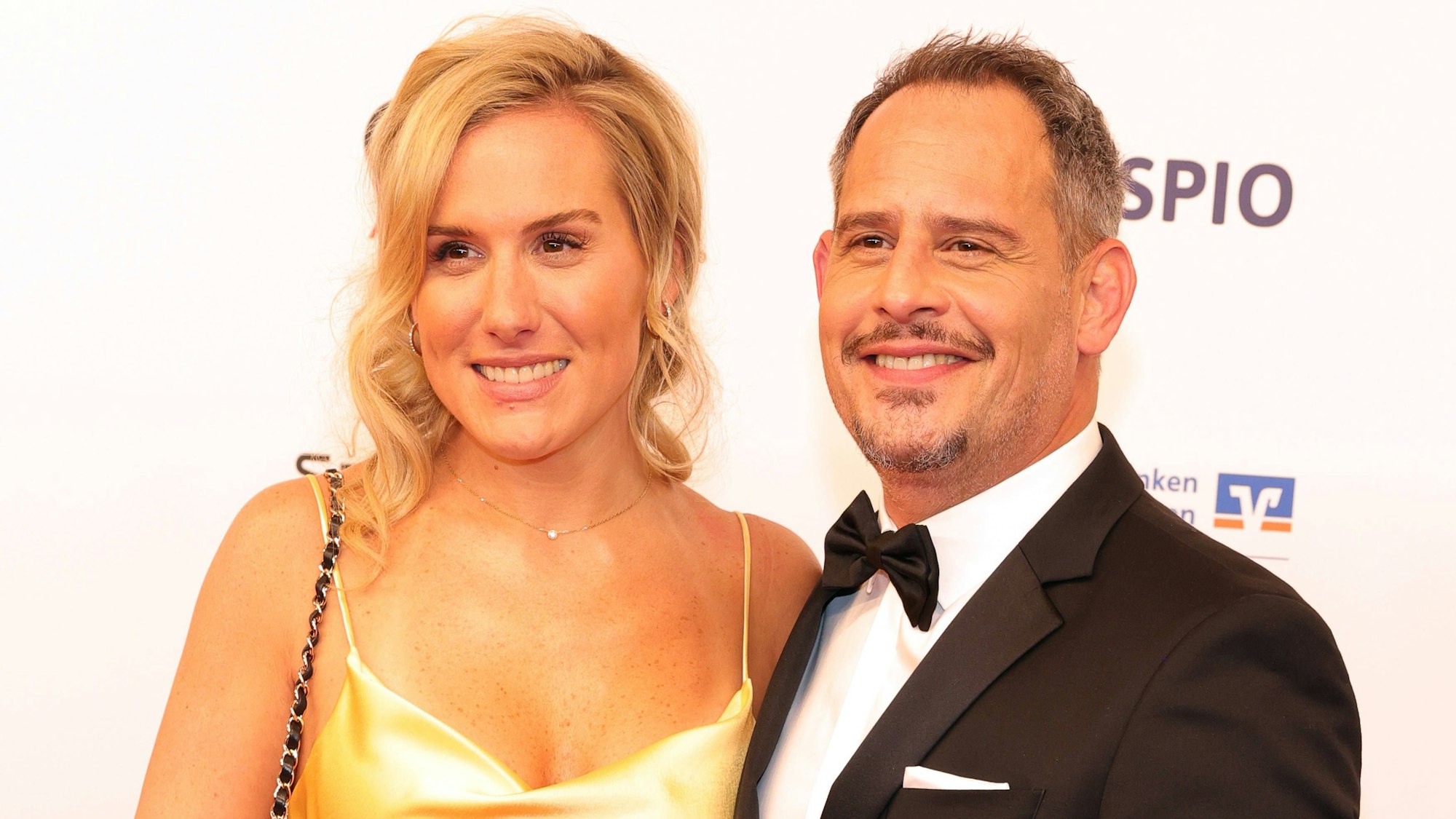 Moritz Bleibtreu mit seiner Ehefrau Saskia Bleibtreu lachen in die Kamera.