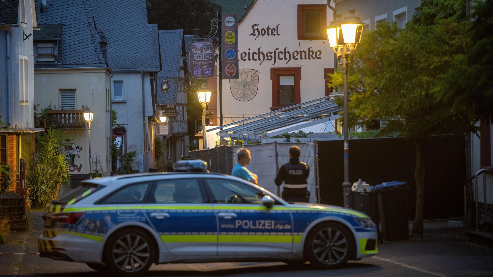 Ein Polizist spricht in der Sicherheitszone eines teilweise eingestürzten Hotels mit einem Passanten.