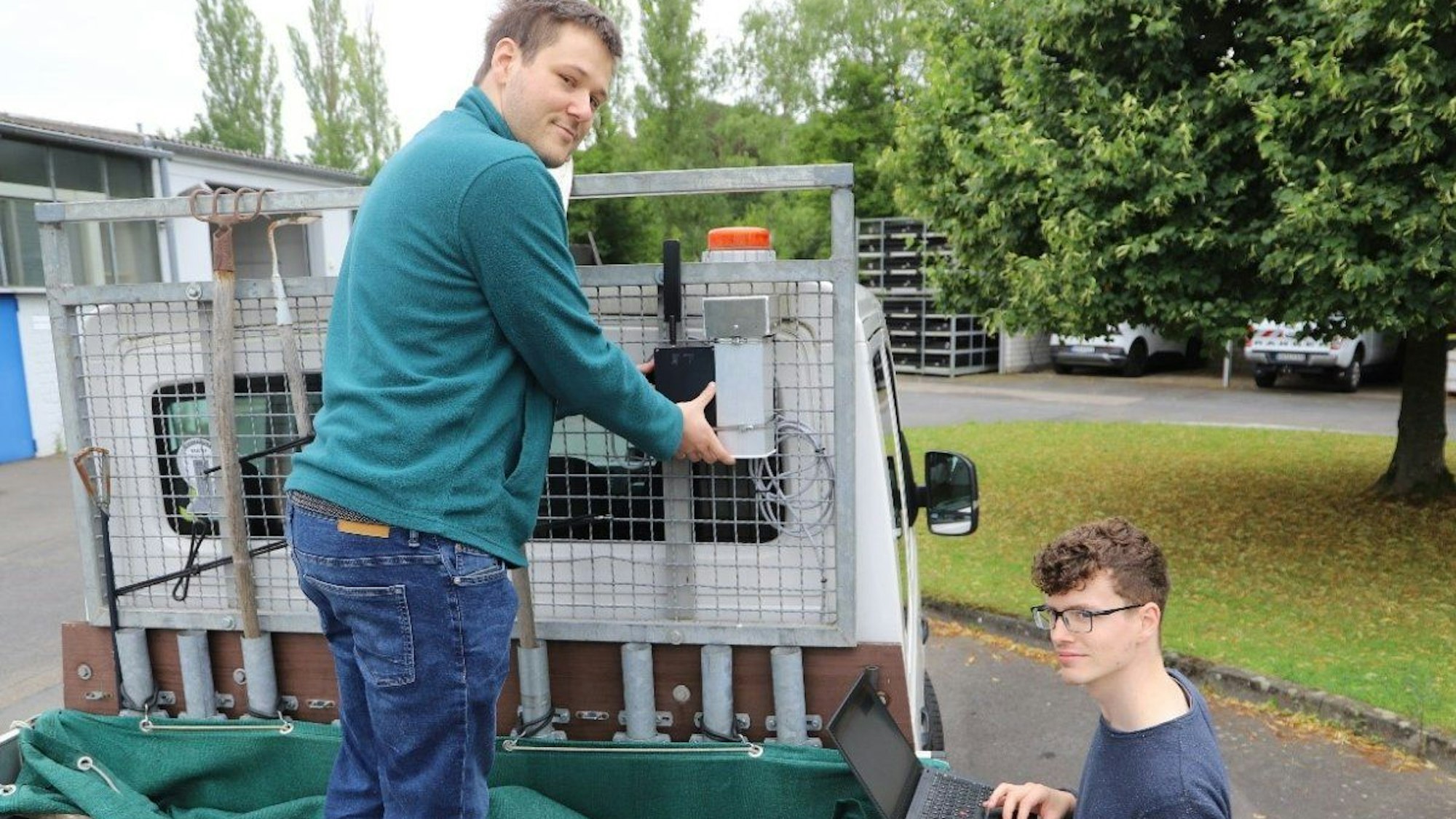 Zwei Mitarbeiter der Stadt montieren Sensoren zur Messung von Umweltdaten an einem Fahrzeug des Lohmarer Bauhofs.