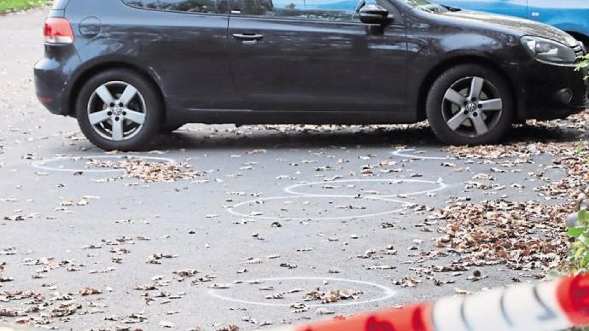 Auf dem Bild ist der Parkplatz zu sehen, auf dem ein Mann in Hürth eine Frau mit Schüssen verletzte. Auf dem Boden sind mit Kreise kreise eingezeichnet. Es parken Autos dort, der Platz ist abgesperrt.
