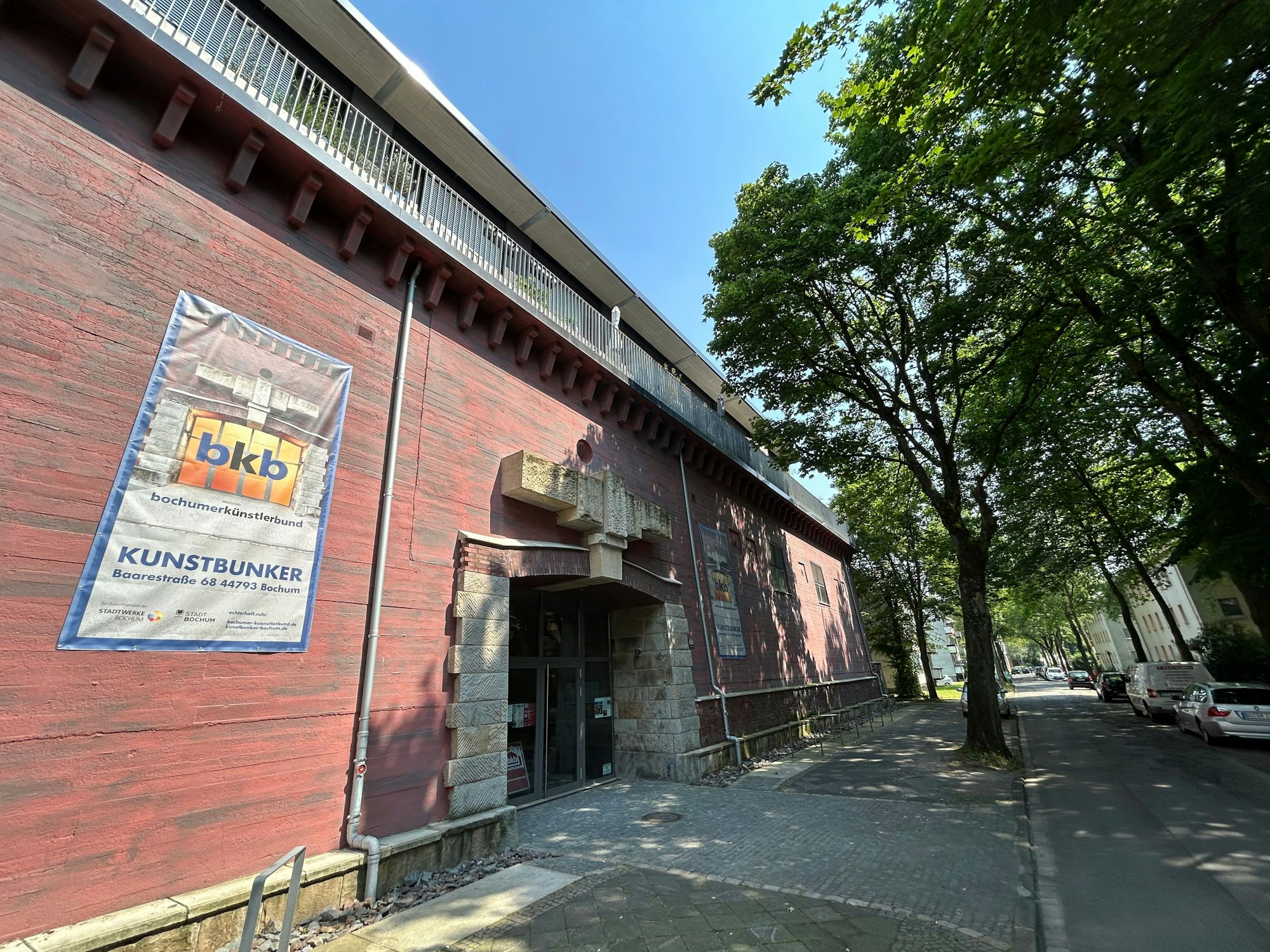 Die rötliche Fassade des Bochumer Kulturbunkers ist zu sehen an einer Straße.