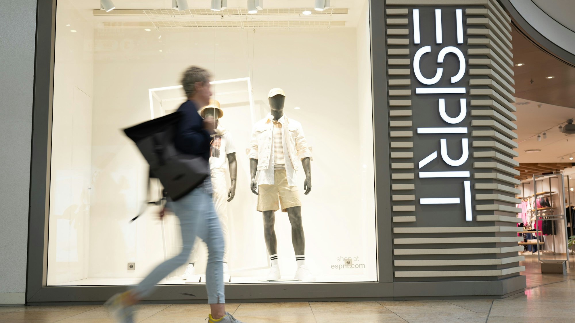 Eine Passantin geht vor einer Filiale des Modekonzerns Esprit entlang.