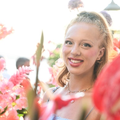 Anna Ermakova steht lachend in einem Blumenmeer.