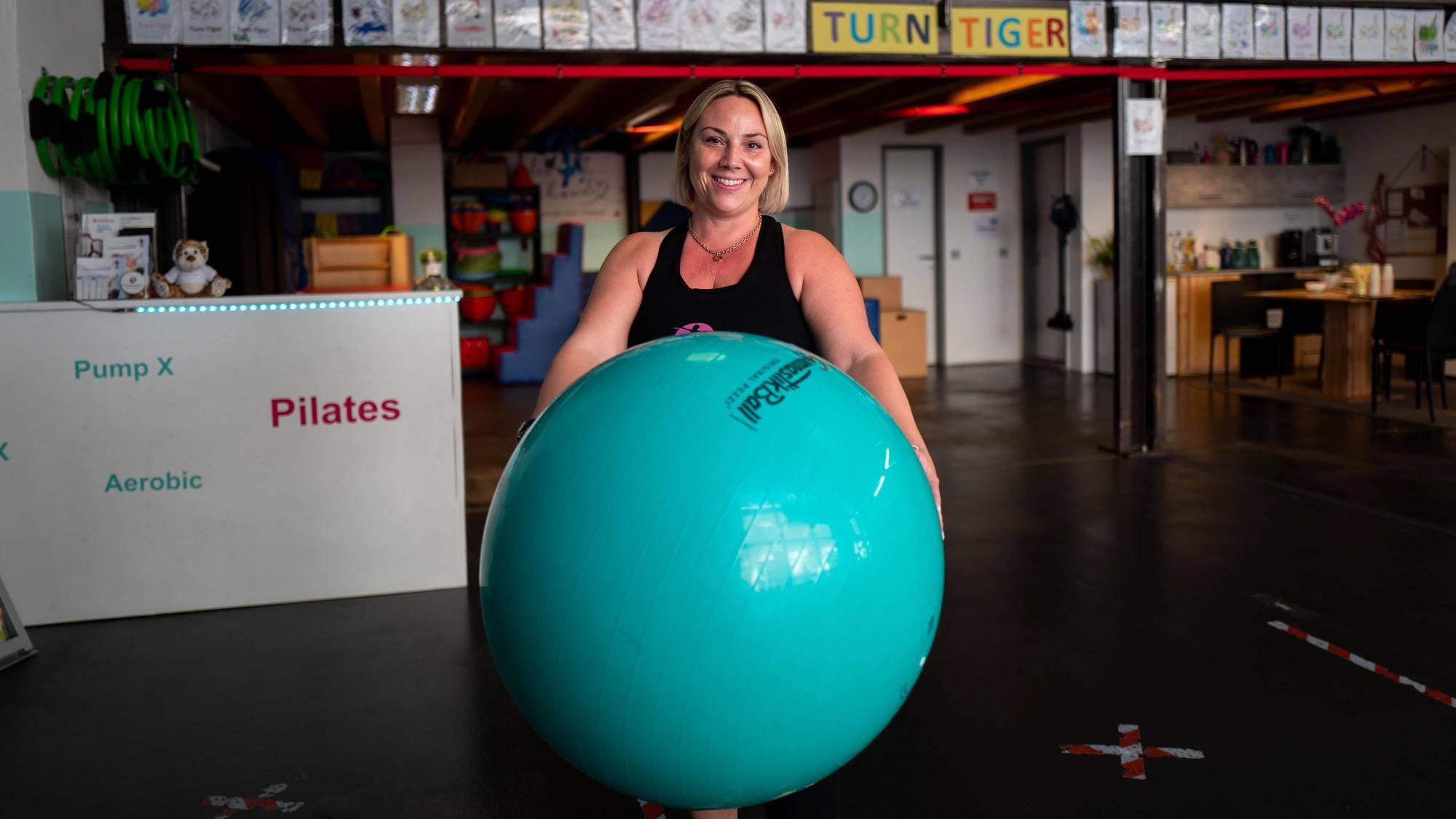 Daniela Springer hält vor sich einen großen Gymnastikball.