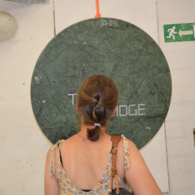 Studierende der Kunstakademie Düsseldorf stellen unter dem Motto „Notes from the underground“ in Siegburg aus.
Die Arbeiten von Luis Romero sorgten für viel Aufmerksamkeit. Eine Frau steht vor einer grünen, runden Scheibe.