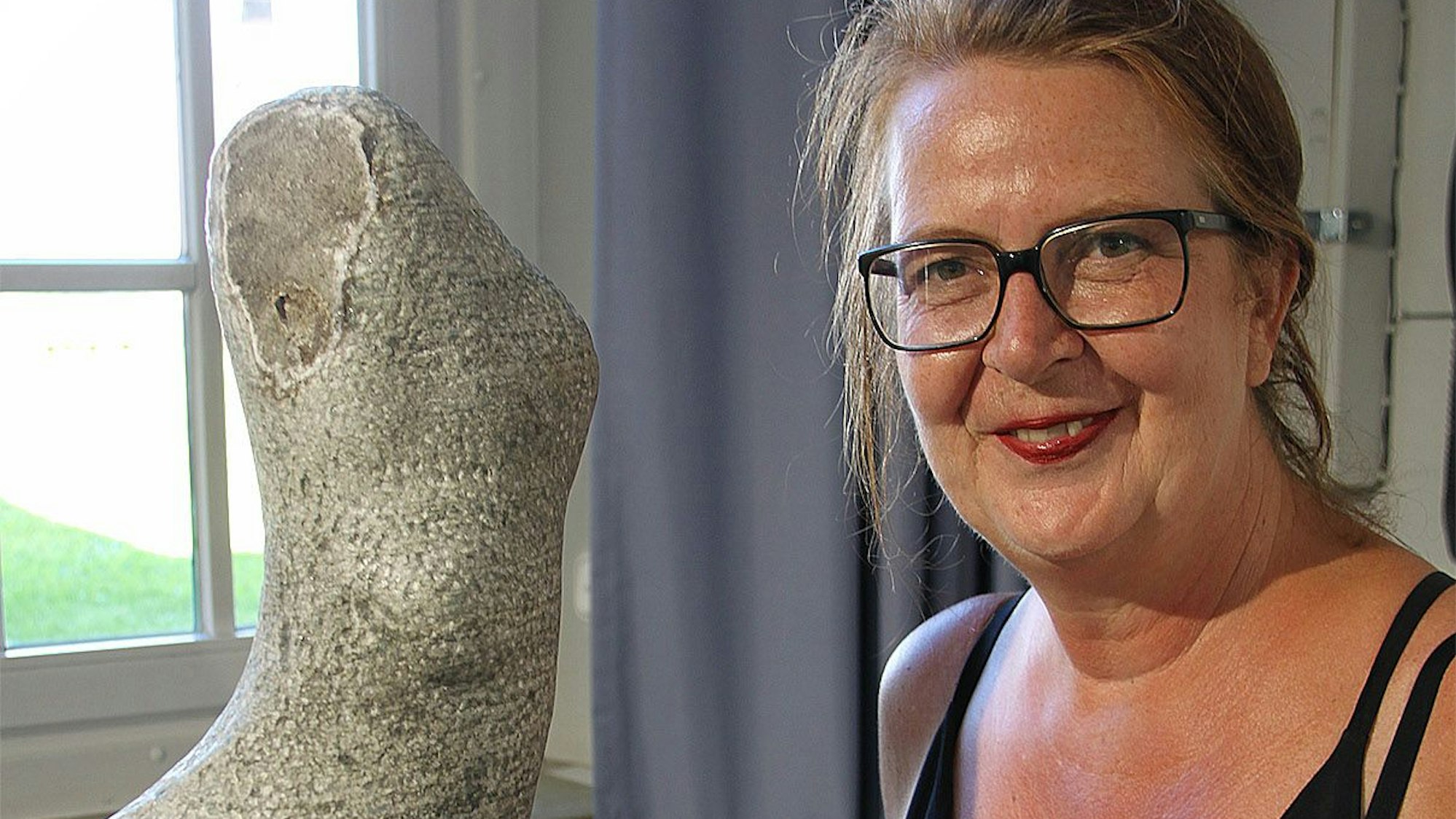 Martina Werheit aus Köln steeht an einer von ihr gefertigten Steinskulpturen. Diese trägt den Titel „Rose“ aus besteht aus grünem Marmor.