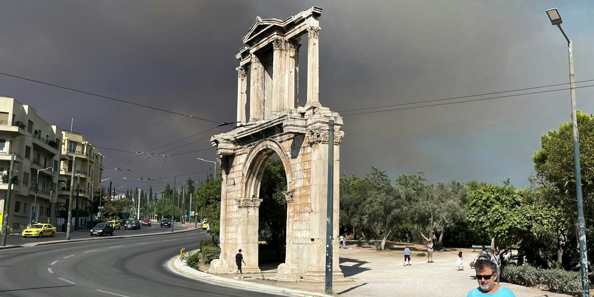 Rauch von Waldbränden ist über dem Hadriansbogen im Stadtzentrum von Athen zu sehen.