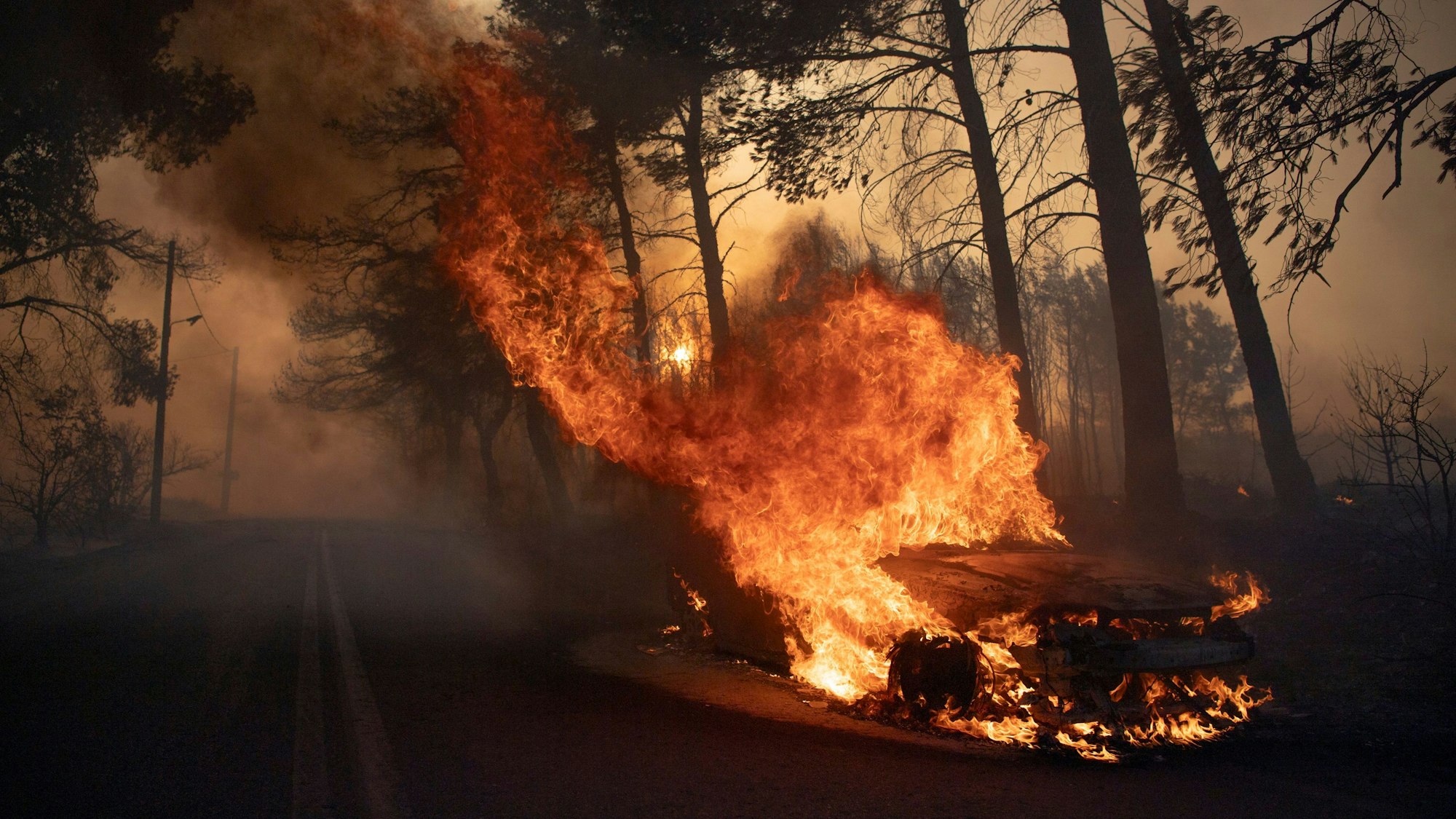 Ein Auto brennt während eines Waldbrandes im Dorf Varnava.