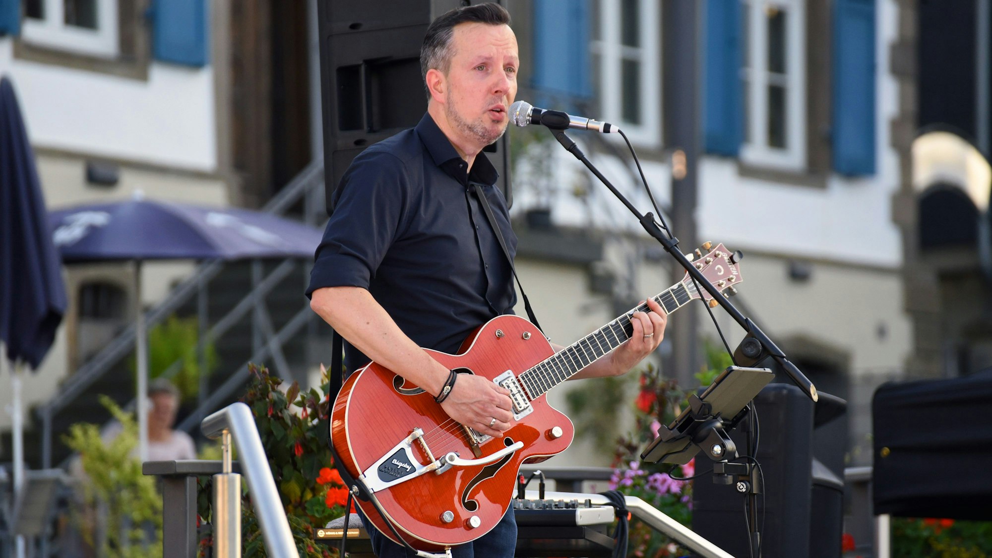 Musiker Daniel Sypien mit einer Gitarre in den Händen bei einem Auftritt.