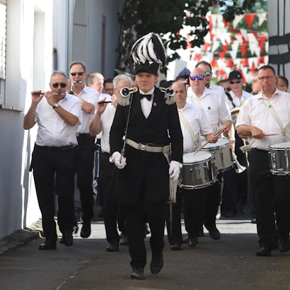 Ein Spielmannszug zieht durch eine Straße.
