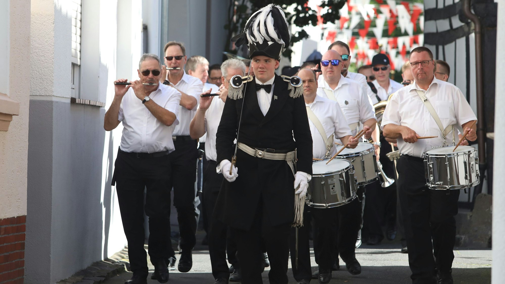 Ein Spielmannszug zieht durch eine Straße.