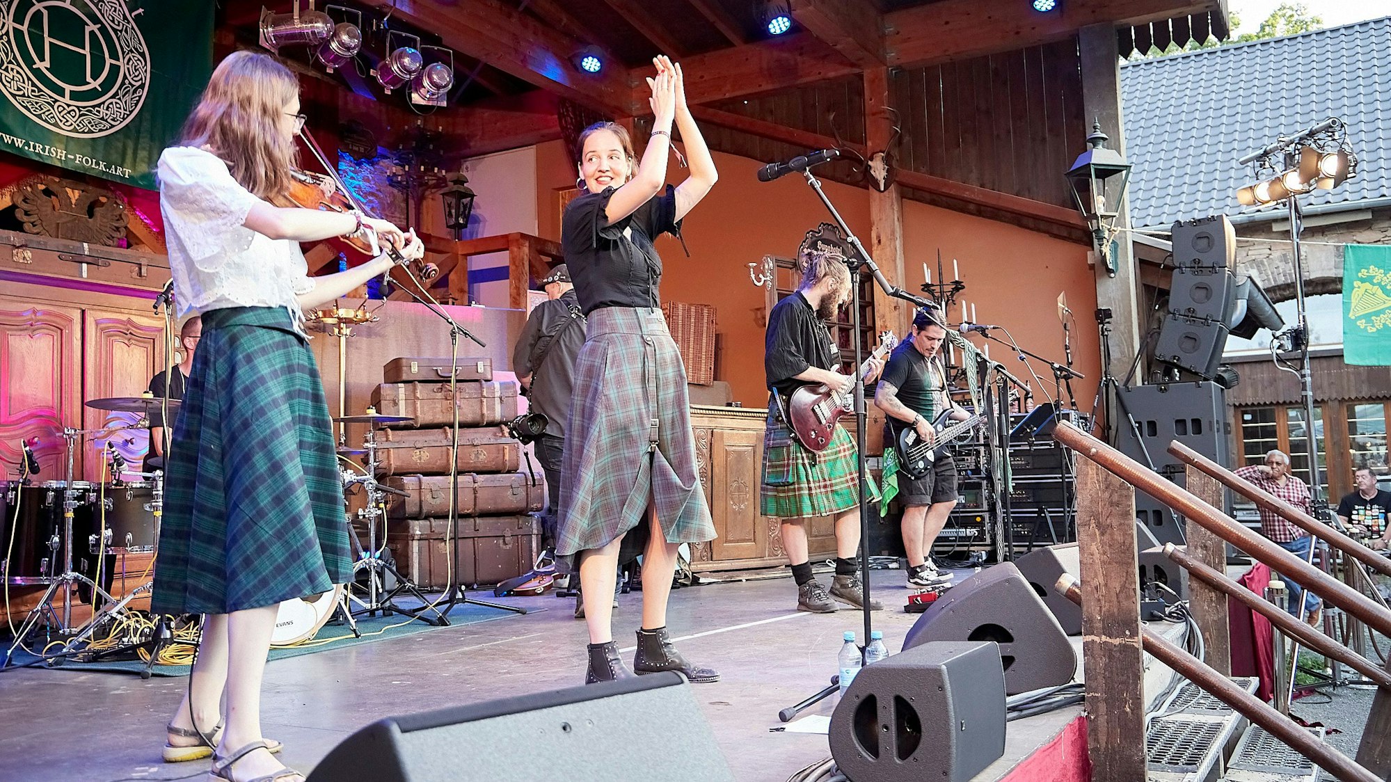 Vier Bandmitglieder stehen auf der Bühne der Burg Satzvey sorgen für Stimmung.
