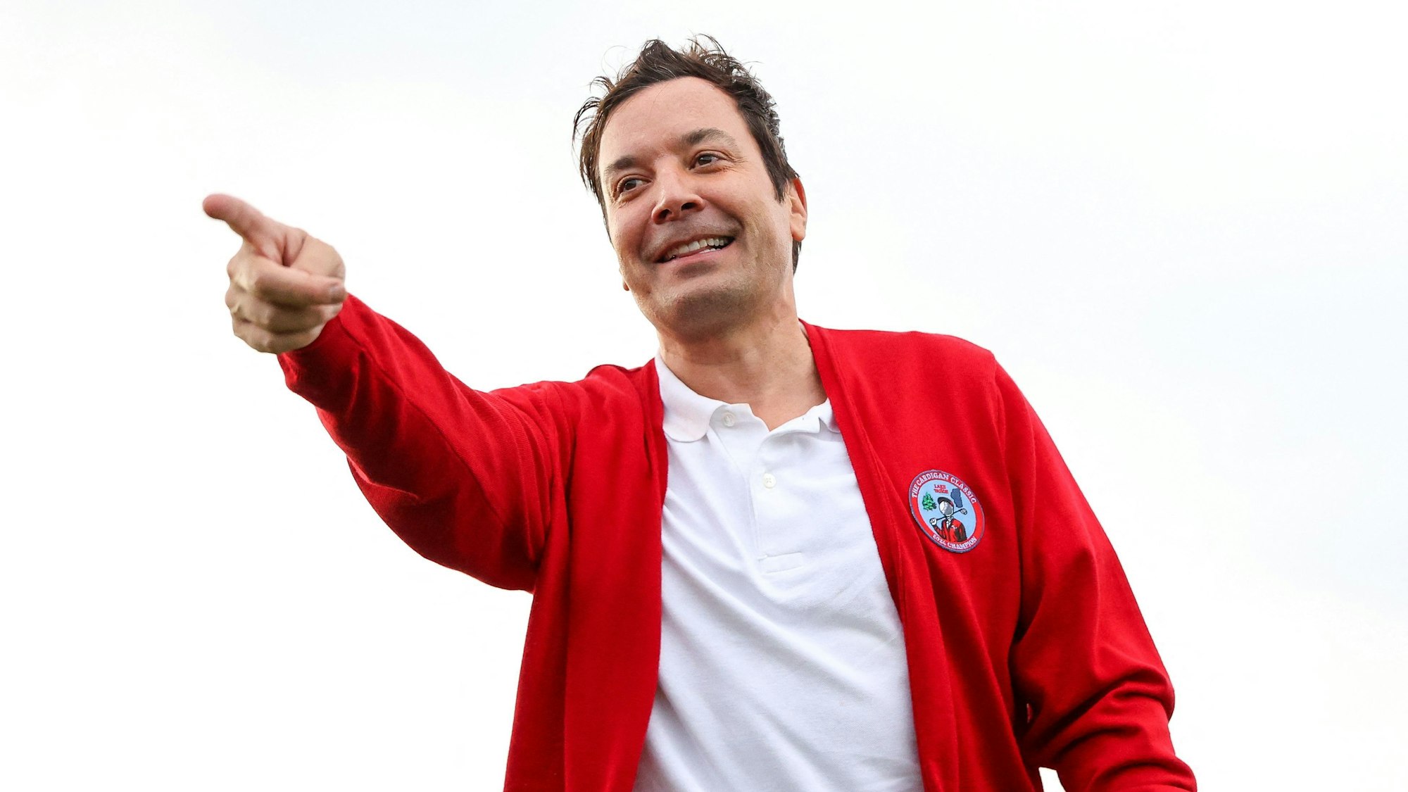 Jimmy Fallon zeigt mit dem Finger auf etwas.