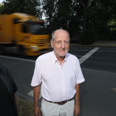 Zu sehen sind Martin Cordemann und Vorstandsmitglied des BUND Kreisgruppe Köln Helmut Röscheisen (v.l.) an der Inneren Kanalstraße. Im Hintergrund fahren ein LKW und ein PKW.