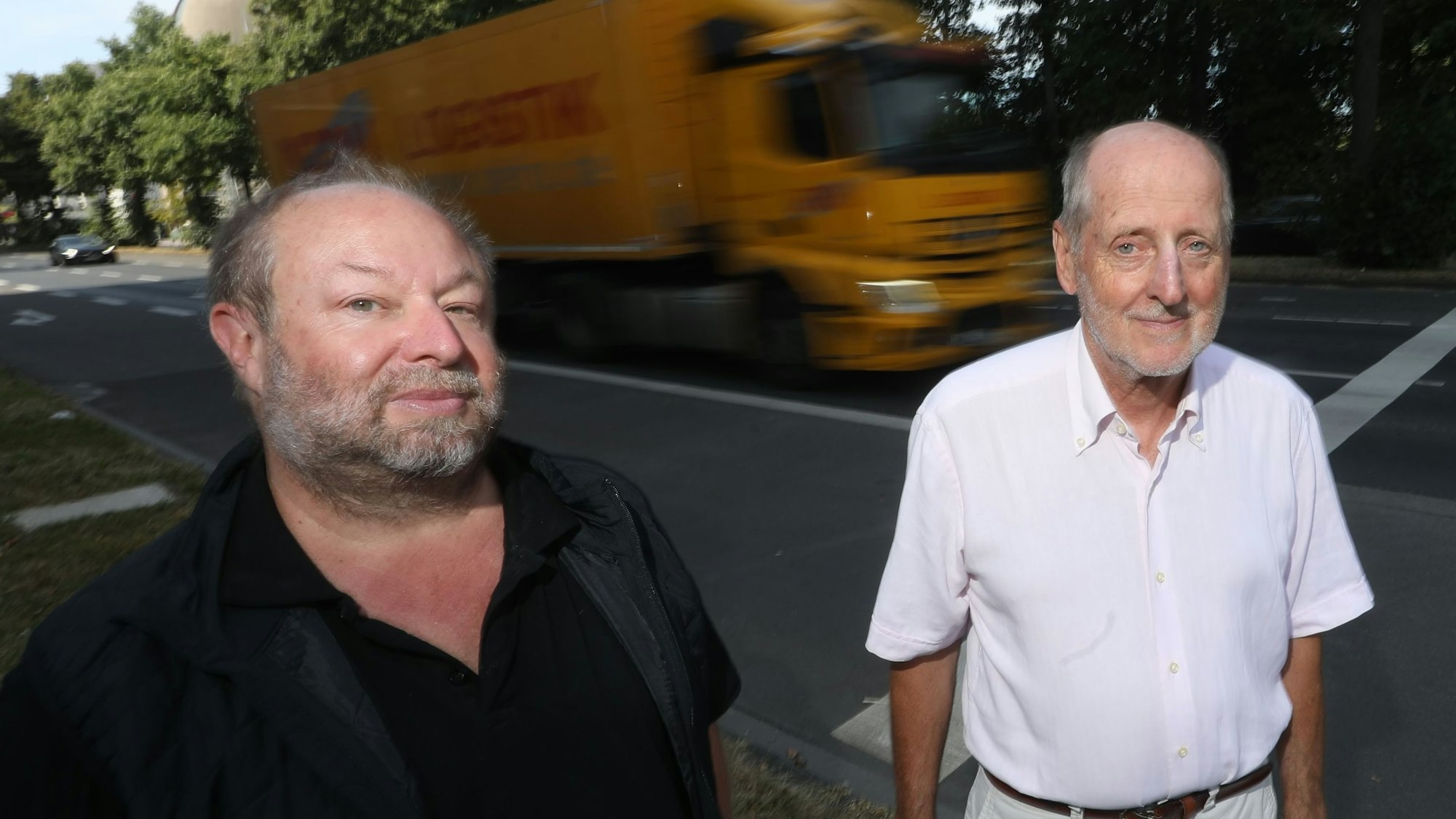 Zu sehen sind Martin Cordemann und Vorstandsmitglied des BUND Kreisgruppe Köln Helmut Röscheisen (v.l.) an der Inneren Kanalstraße. Im Hintergrund fahren ein LKW und ein PKW.