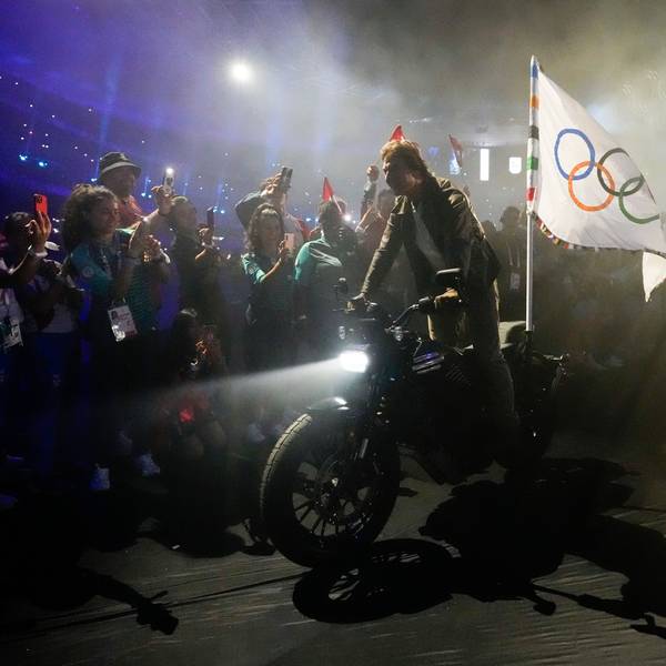 11.08.2024, Frankreich, Saint-Denis: Tom Cruise fährt auf einem Motorrad mit der olympischen Flagge während der Abschlussfeier der Olympischen Sommerspiele 2024 im Stade de France.