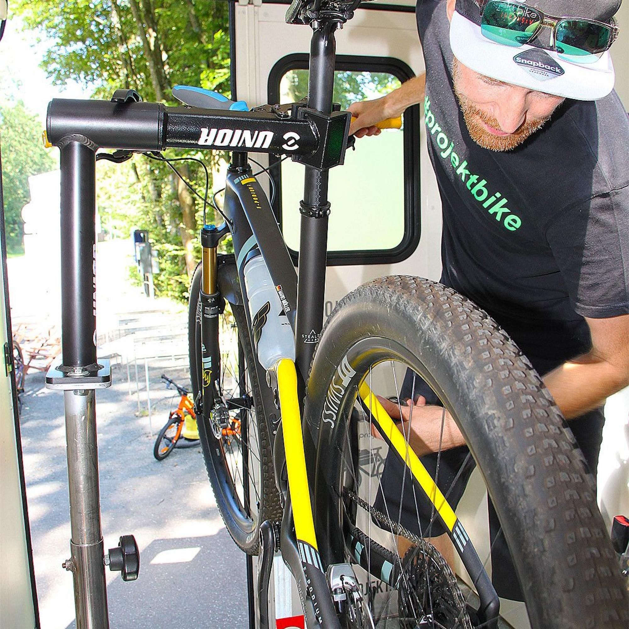 Ein Zweiradmechaniker arbeitet an einem Mountainbike.