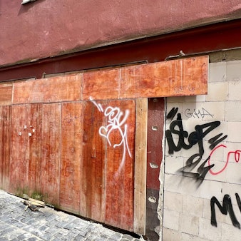 Ein Eckhaus mit Bretterverschlag und Farbschmierereien