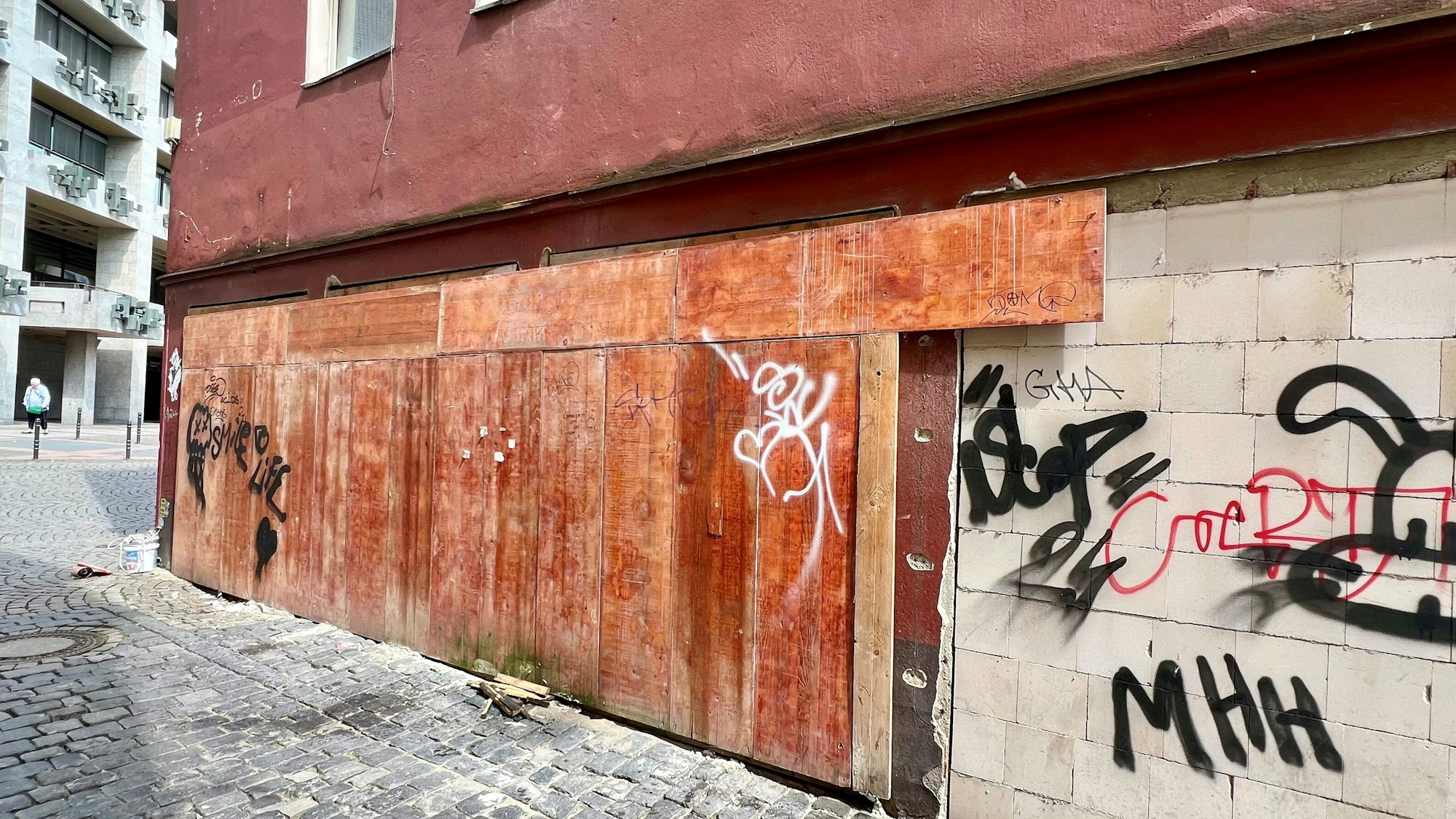 Ein Eckhaus mit Bretterverschlag und Farbschmierereien