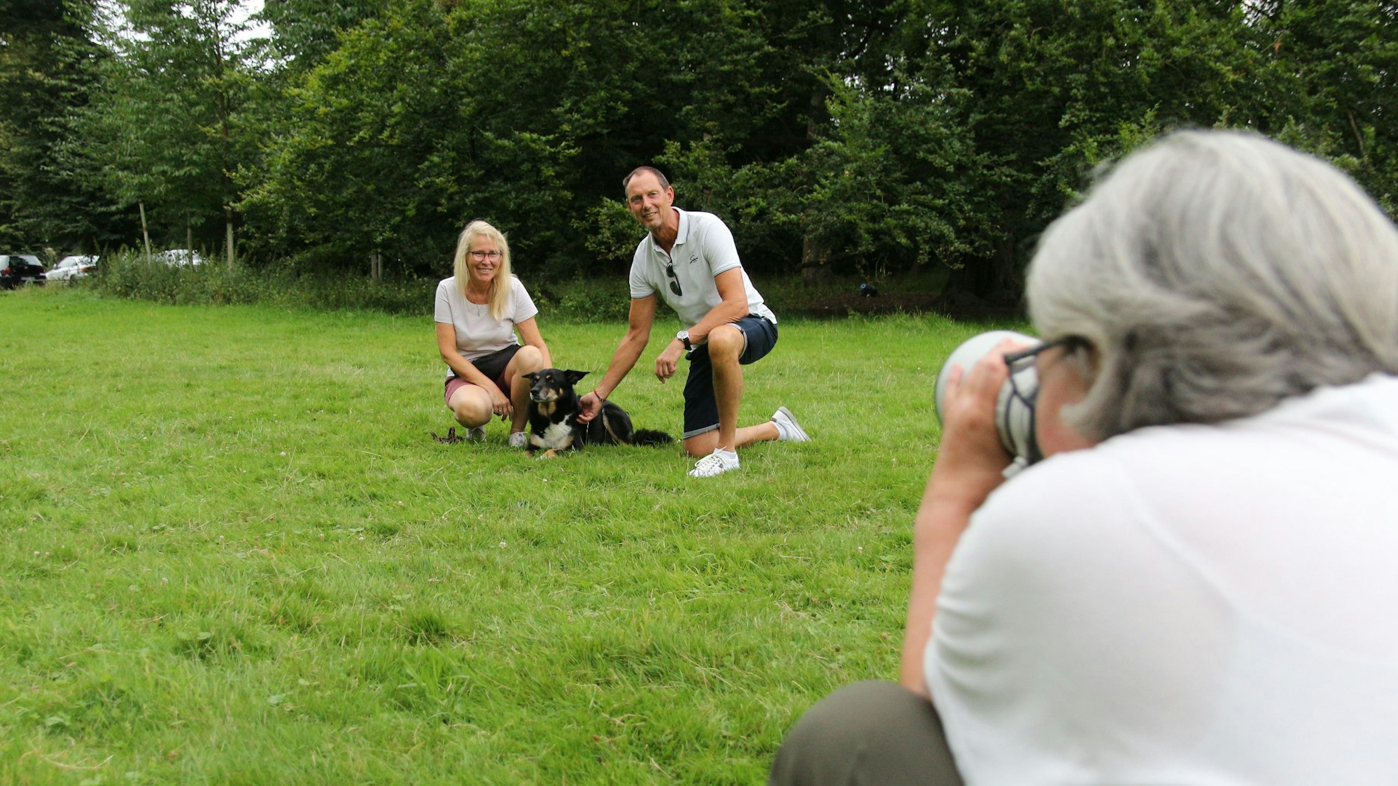 Auf dem Foto sind Hundebesitzer mit ihrem Hund und der Fotografin zu sehen.