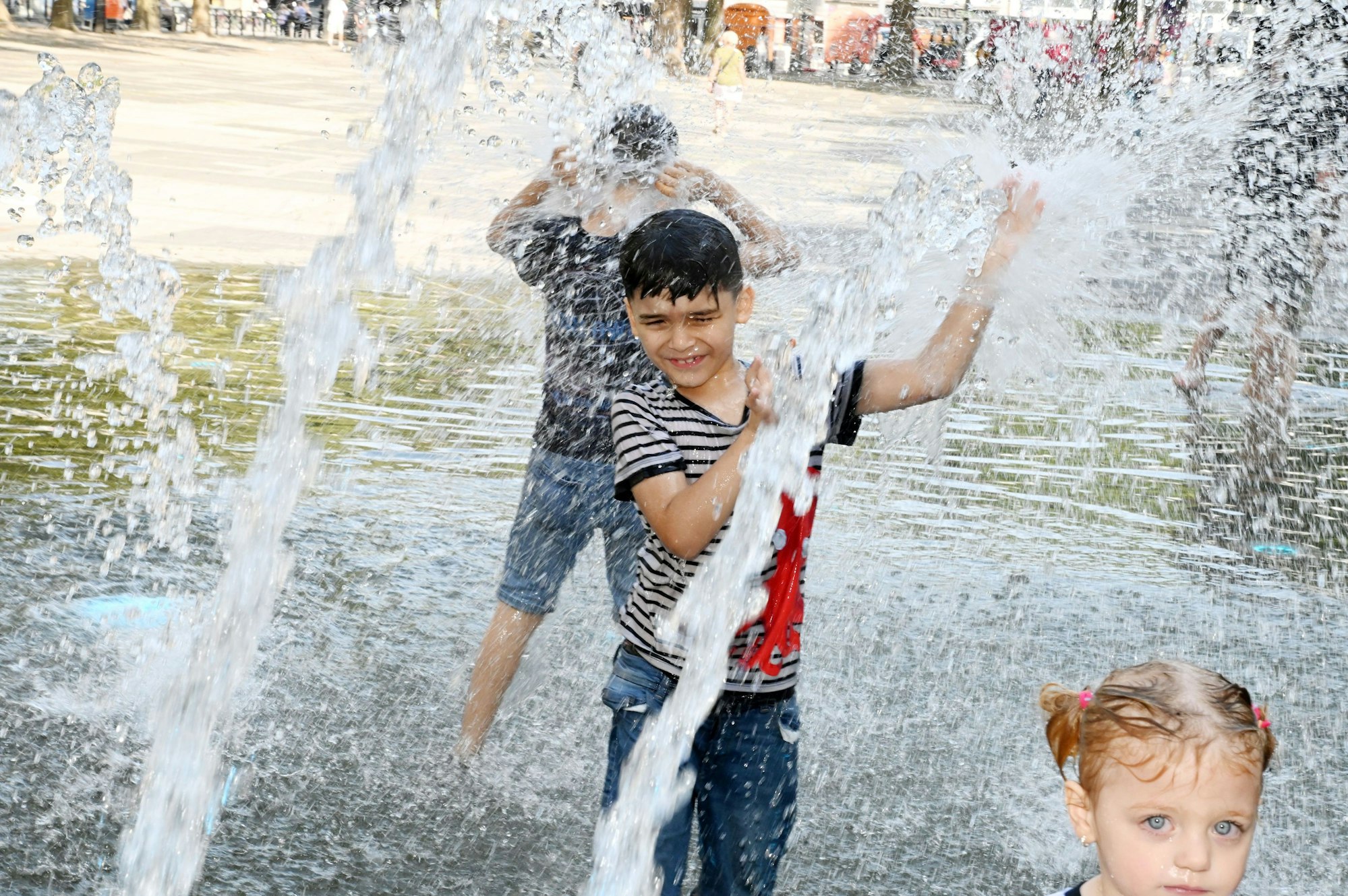 Das Bild zeigt spielende Kinder im Brunnen am Neumarkt.