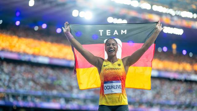 Yemisi Ogunleye hält nach ihrem Gold-Erfolg bei Olympia eine Deutschland-Fahne in die Luft.