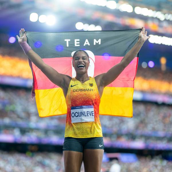 Yemisi Ogunleye hält nach ihrem Gold-Erfolg bei Olympia eine Deutschland-Fahne in die Luft.