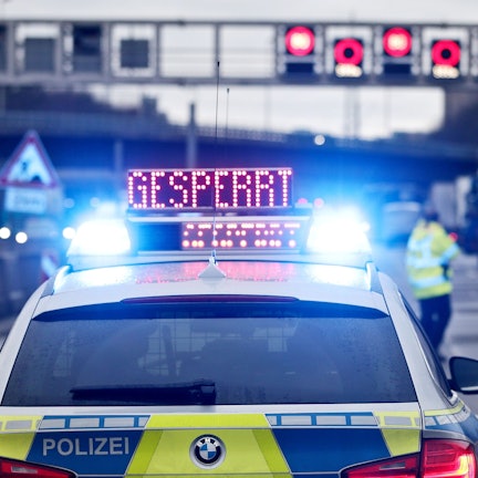 Ein Polizeifahrzeug leuchtet in der Nacht, darauf der Schriftzug 'Gesperrt'.