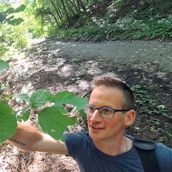 Wegepate Timo Stein schneidet eine Markierung am Bergischen Weg auf dem Lüderich bei Overath frei.
