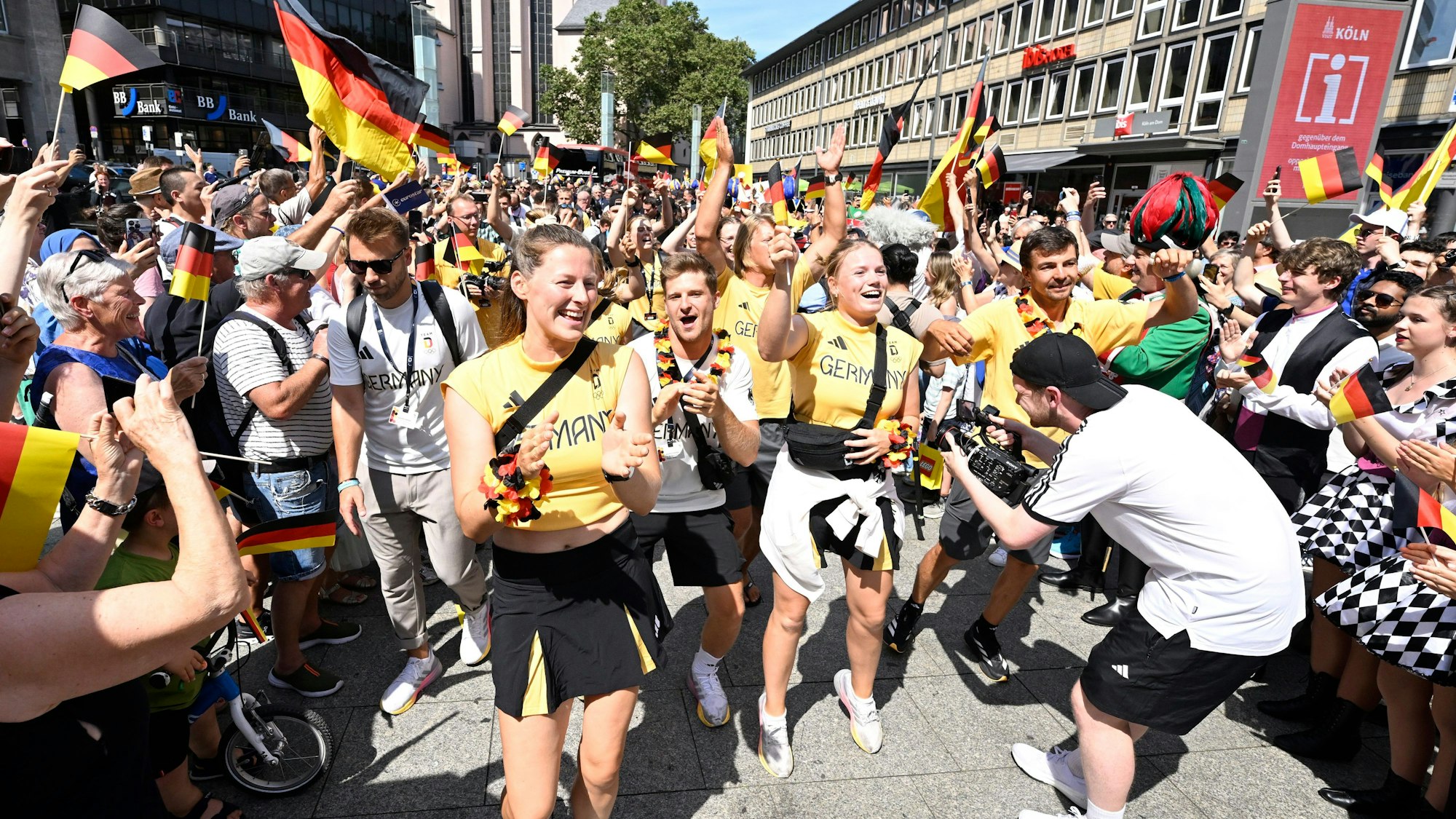 Hunderte von Fans stehen dicht gedrängt auf dem Kölner Bahnhofsvorplatz, um die aus Paris zurückgekehrten deutschen Olympia-Teilnehmer zu begrüßen. In der Menschenmenge werden Dutzende Deutschland-Flaggen geschwenkt.