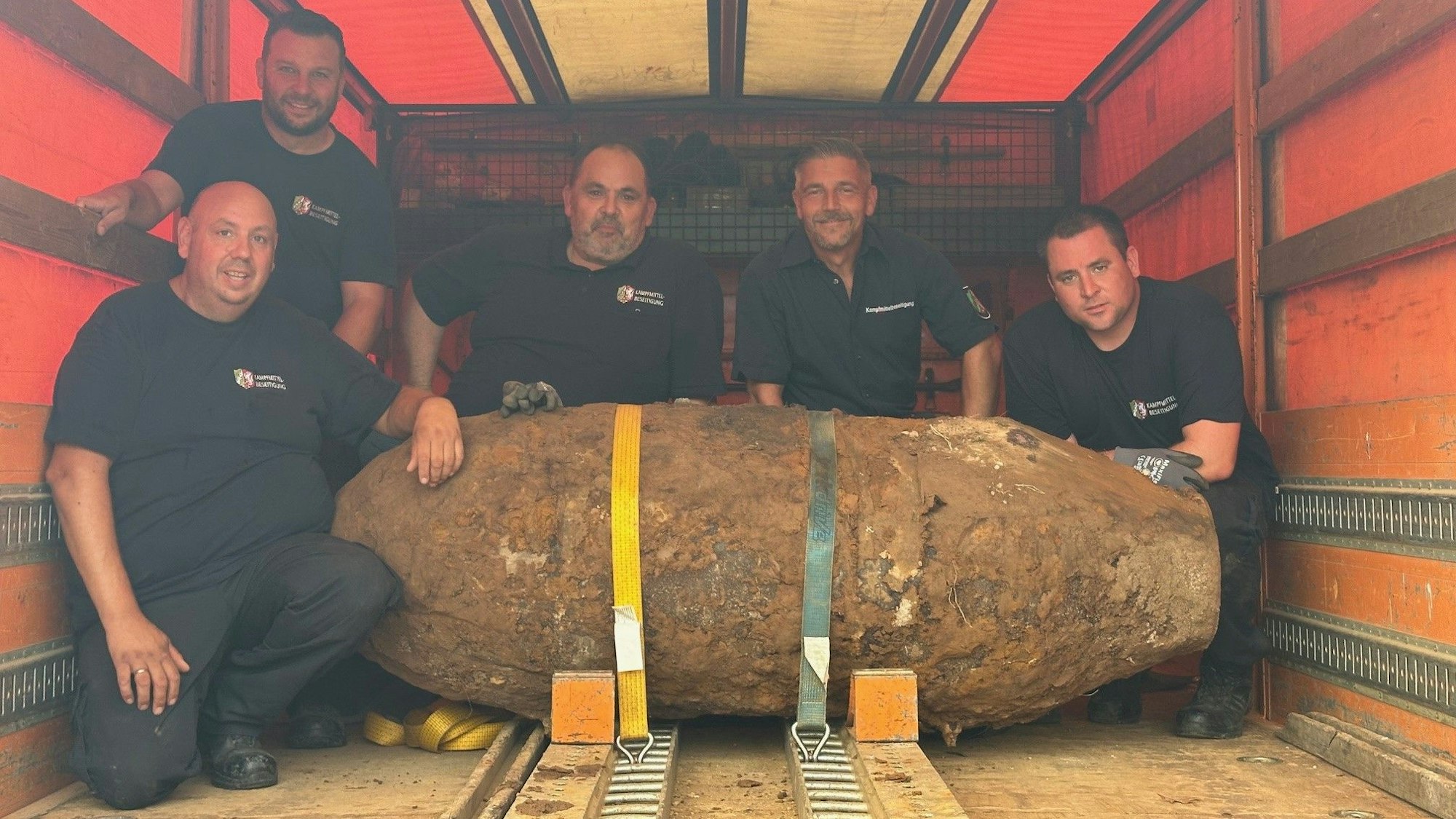 Mitarbeiter des Kampfmittelbeseitigungsdienstes stehen um die entschärfte20-Zentner-Bombe herum.