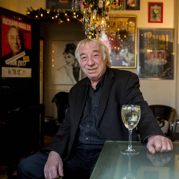 Richard Rogler sitzt vor einem Glas Wein in einer Kneipe.
