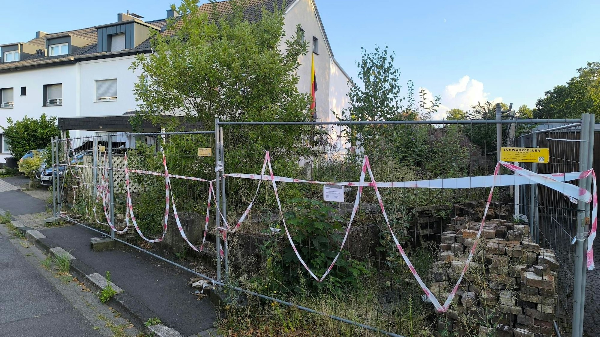 In der Reuterstraße in Leverkusen-Schlebusch steht eine Vielzahl an leerstehenden Häusern, Baustellen und halbfertigen Abbrüchen. Eines dieser Gebäude ist hier zu sehen, hinter einem Baustellenzaun.