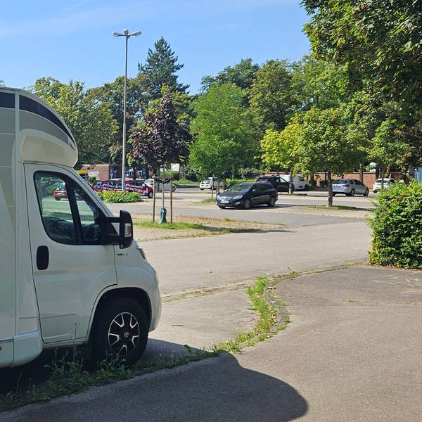 Ein Wohnmobil steht auf einem Parkplatz in Kaster.