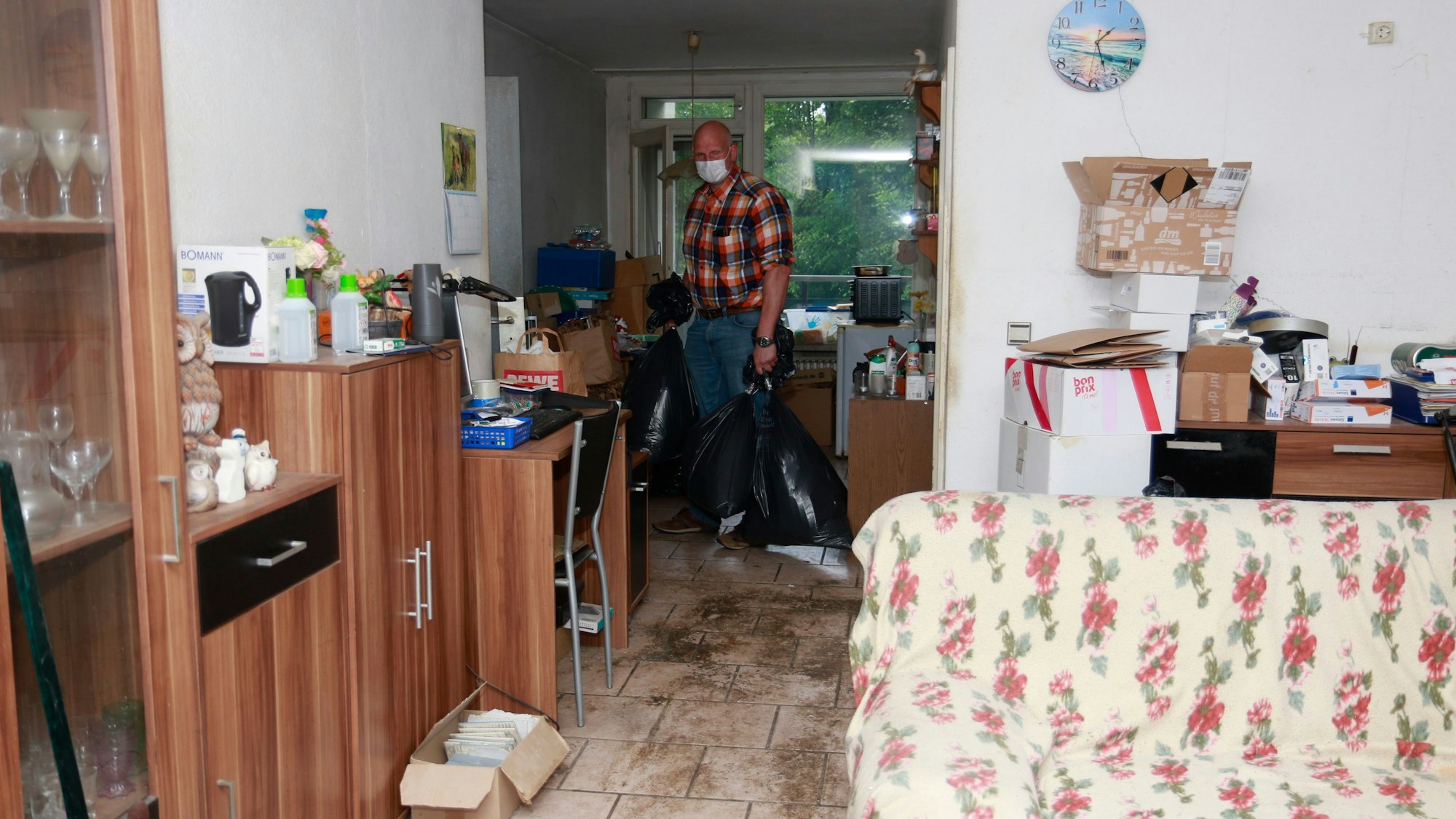 Köln: Der Eigentümer der Wohnung kommt den Mietern zu Hilfe und entsorgt Müllsäcke. Müllsäcke und Pakete prägen das Bild in dieser Wohnung.