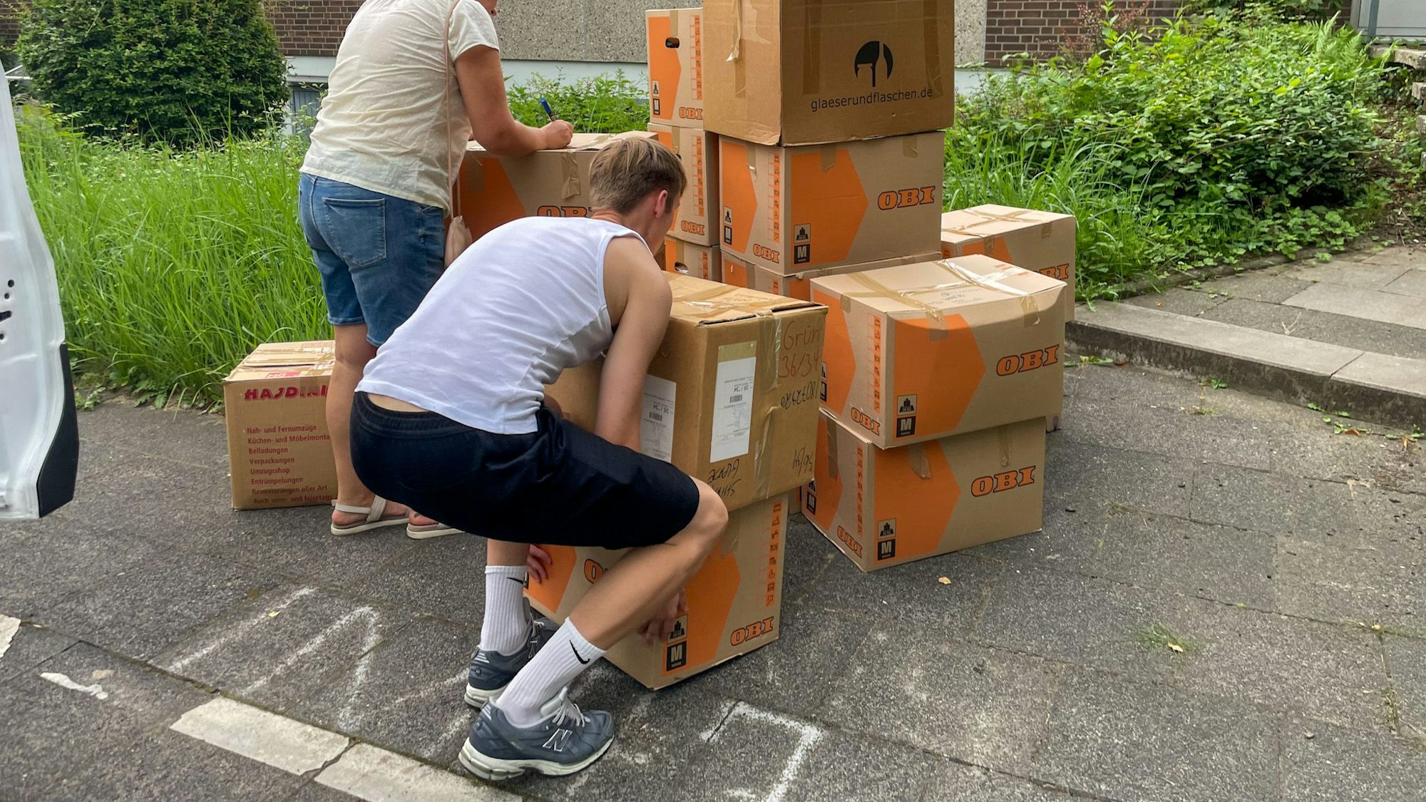 Menschen schleppen Kisten.