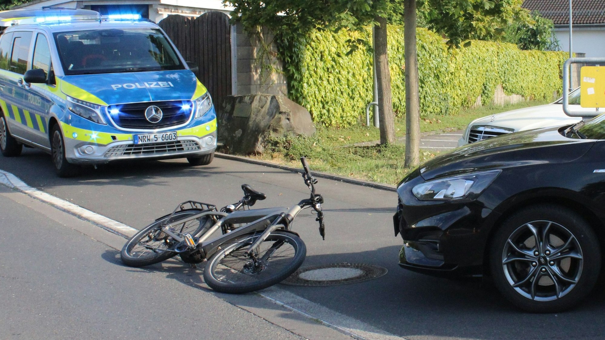 Ein verunfalltes Pedelec liegt nach einem Unfall halb auf der Kölner Straße in Rösrath.