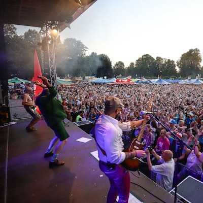 Menschenmenge vor Musikern auf der Bühne.