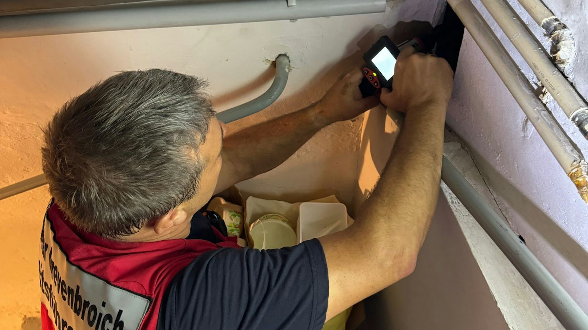 Mit einer Endoskop-Kamera sucht ein Feuerwehrmann nach dem verschwundenen Tier.