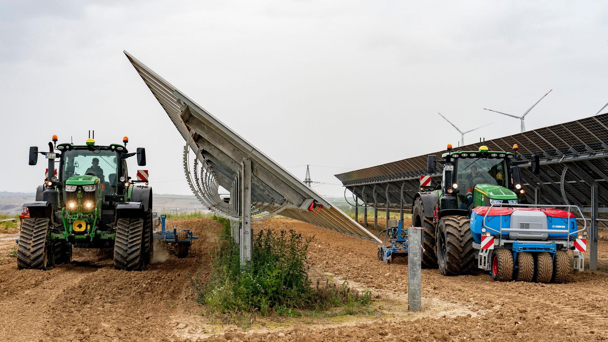 Agri-Solar in Jackerath: Solarpaneele und Trecker sind auf einem Acker zu sehen.