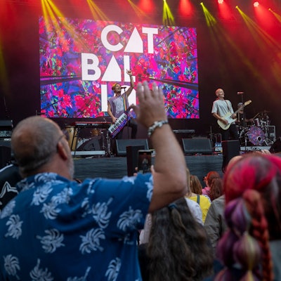 Viele Menschen tanzen vor einer Bühne. Auf der Bühne performt die Kölner Band Cat Ballou.