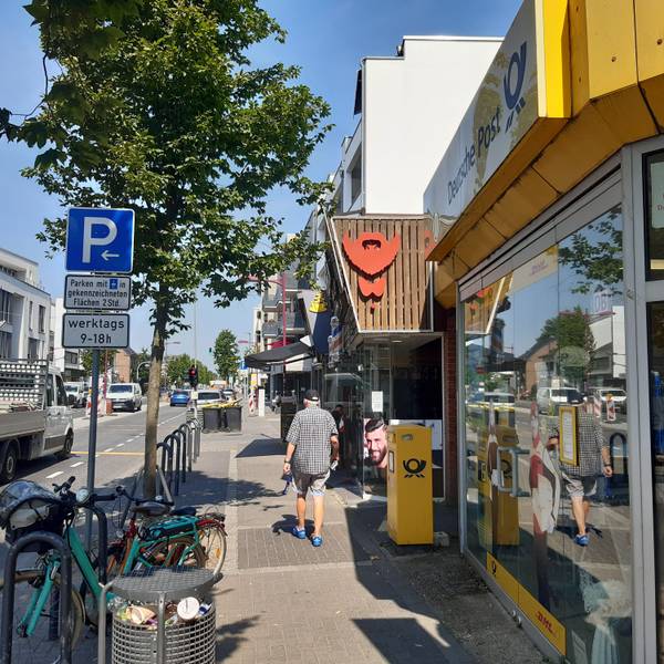 Auf dem Bild ist die Kerpener Straße rund um das Café Dackweiler zu sehen, ein älterer Herr flaniert über den Bürgersteig.